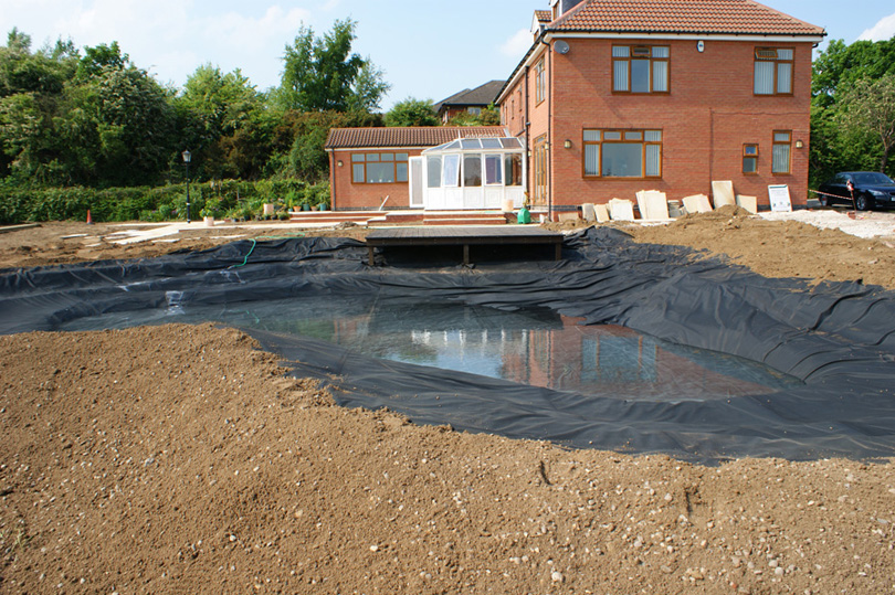The liner is in place and the bank around the pond has been constructed.
